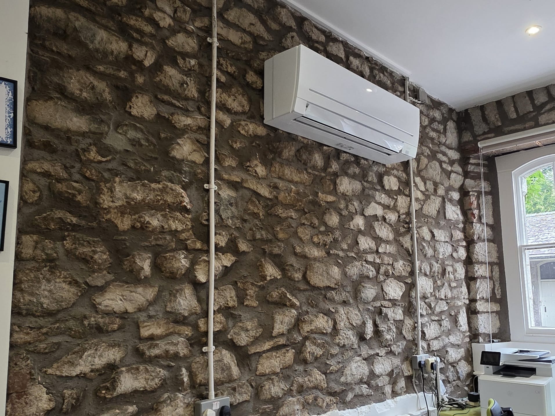 Indoor unit mounted on exposed stone wall
